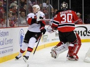 Senators right wing Chris Neil dodges the stick of New Jersey Devils goalie Martin Brodeur.
(Reuters)
