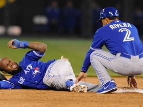 Toronto Blue Jays shortstop Jose Reyes (L) reacts to the pain after hurting his ankle while trying to steal second as third base coach Luis Rivera comes to help in the sixth inning against the Kansas City Royals at their MLB American League baseball game in Kansas City, Missouri April 12, 2013.  (REUTERS)