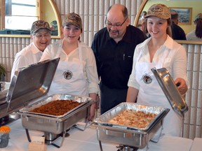 Timmins Fur Council president Jodie Russell hungrily eyes serving dishes containing lynx and moose sausage and fresh salmon. The Fur Council hosted its ninth-annual Wildlife Dinner on Saturday at Timmins Inn and Suites. Getting ready to serve are, from left, event head chef Lil McCord, Samantha Prince, Russell, and Katelynn Gravelle.