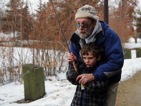 Peace Country Flyfishers Association president Jim Epp helps five-year-old Nolan Edey catch a cardboard trout statio at the Get Outdoors Weekend celebration. (Elizabeth McSheffrey/Daily Herald-Tribune)