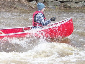 Eric Lamarche and Aaron MacCulloch manage to get through the Cornwall Township Road 22 bridge rapids during the Raisin River Canoe Race, Sunday, east of St. Andrew's.
Staff photo/GREG PEERENBOOM