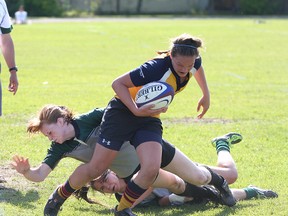 Napanee Golden Hawks’ Brittany Edwards eludes some Holy Cross Crusaders tacklers during a high school girls rugby game last year. The spring season starts Tuesday. (Whig-Standard file photo)