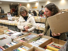 Cathy Richards, left, sifts through paperbacks and hardcovers at the North Bay Public Library book sale, Saturday, with Deena Duff doing the same. The sale of videos, DVDs, magazines and encyclopedias continues today through Wednesday 9:30 a.m. to 8:30 p.m.