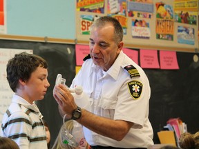 Brant county paramedic duty manager Randy Papple shows students how a BVM (bag valve mask) works on Brody Wright at North Ward Public School on Thursday, April 4, 2013 during the school's math-themed career day. Students could choose to learn about careers such as graphic design, urban and rural planning, police investigation and many more from professionals who volunteered to speak at the school. MICHAEL PEELING/The Paris Star/QMI Agency
