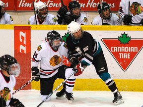 Peterborough Quacks (2) Barry Kramer, left, is tied up by Winchester Kemptville Mighty Docs' Terry Brennan during the 30th anniversary of the Docs On Ice hockey tournament on Saturday, Mar. 31, 2012 at the Memorial Centre. Proceeds from the event benefit the Peterborough Youth Sports Concussion Program. (QMI Agency file photo)