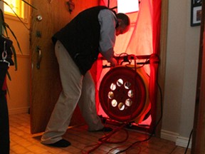 Alex Wilde, of Wilde Ridge Energy Consultants, conducts a blower door test Friday during a home energy audit at Shelley Bend's house.