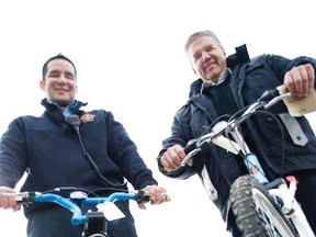 Portage la Prairie firefighter Curtis Rance (left) and fire chief Phil Carpenter pose with bikes that will be auctioned off for the department's annual Firefighters Burn Fund. (File photo)