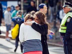 One woman comforts another after two explosions stopped the Boston Marathon on Monday. (DOMINICK REUTER/Reuters)