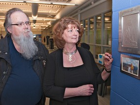 BRIAN THOMPSON, The Expositor

Brantford artist Mark Neddow and Catherine Camp-Paynter look at a plaque unveiled Tuesday in the new weight room at the Wayne Gretzky Sports Centre in tribute to Camp-Paynter's husband, Gord Paynter, who died last year on April 16.