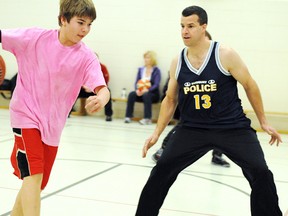 Ryan Fisher dribbles past Sergeant Marc Brunette of the Greater Sudbury Police Service at Queen Elizabeth School on Monday evening.

GINO DONATO/THE SUDBURY STAR