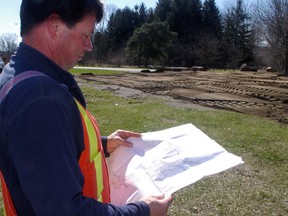 Trevor McElhone, of CJDL Consulting Engineers, Tillsonburg, looks over plan for reconstruction of road at Pinafore Park. The work has raised concern the city is paving over parkland. Photo taken April 17, 2013. Eric Bunnell/QMI Agency/Times-Journal