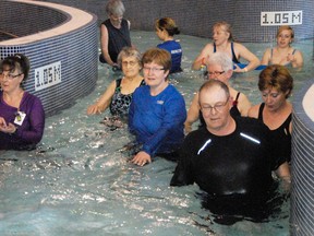 Instructor Sandee Watson (centre) leads a group of clients through a series of aqua movement therapy exercises in the Lazy River at the Eastlink Centre (10 Knowledge Way) on Tuesday. The therapy uses the resistance of the river’s current to build muscle strength in people who have difficulty with movement. (Elizabeth mcSheffrey/Daily Herald-Tribune)