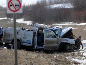 An RCMP officer inspects the wreckage of a collision that sent three people to hospital Tuesday. The collision occurred on Highway 2 just north of Sexsmith near Range Road 55, when the northbound service truck (right) crossed the centre line for an unknown reason, colliding with another pick-up. The three – two from the service truck and one from the pick-up – were sent to Queen Elizabeth II Hospital with undetermined injuries. ADAM JACKSON/DAILY HERALD-TRIBUNE