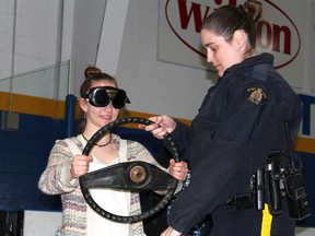 Cst. Christina Wilkins of the Wood Buffalo RCMP helps a student find her balance before she tries to walk while wearing impairment goggles. JORDAN THOMPSON/TODAY STAFF