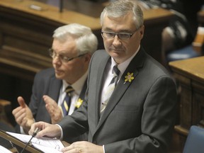 Stan Struthers delivers the budget at the Legislative Building in Winnipeg flanked by Premier Greg Selinger.