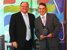 Jordan Rumor (right) shows off his Outstanding Young Professional Award that he received at the Economic Developers Alberta conference last week.