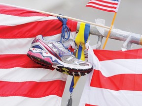 A running shoe with the date of the Boston Marathon bombings written on it, hangs beside a Boston Marathon medal and a small U.S. flag at a makeshift memorial along Boylston Street in Boston, Massachusetts.
REUTERS/Jessica Rinaldi