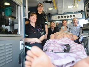 Paramedic Jennifer Lawrence and EMT Sonja Larsen, left, are joined by (L to R) Ian McEwan, AHS medical training coordinator: simulation, University of Calgary human factors research associate Greg Hallihan with Ward of the 21st Century, as well as Brent Thorkelson, senior staff development officer: EMS in the back of an ambulance Thursday at Evergreen Park. The five spent a good part of the day together running simulations as part of a province-wide research project, which is the first of its kind in Canada. (Adam Jackson/Daily Herald-Tribune)