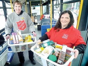 The Salvation Army's Andrew Glenfield and Stratford House of Blessing's Jean Schwartzentruber show some of the non-perishable food items welcomed in the Stuff-A-Bus challenge at Zehrs on Saturday. (SCOTT WISHART, Beacon Herald)
