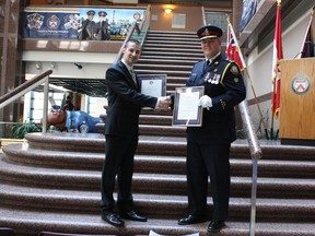 Police Chief Bill Blair congratulates security guard Gregory Van Hee on receiving his Community Members Award for acts of bravery and providing assistance to the Toronto Police. (JUSTIN SMITH, Toronto Sun)