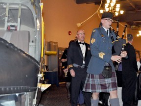 The air force piper escorts those seated at the head table, including the commandant of 3 Canadian Forces Flying Training School, Lieut.-Col. Peter Fedak, at the start of the RCAF ball, past the body of a training helicopter located in the ballroom at Canad Inns. (CLARISE KLASSEN/PORTAGE DAILY GRAPHIC/QMI AGENCY)