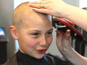 Cami Carpenter talks to her friends while hairdresser Crystal Wood shaves her head. Cami raised money to shave her head in honour of her uncle who passed away from cancer, all money raised will go to the Lake of the Woods Hospital Foundation, the Canadian Cancer Society and the twinning of the Kenora Recreation Centre.
GRACE PROTOPAPAS/Daily Miner and News