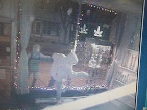 A suspect reaches in to grab a storefront product at In Your Dreams on Montreal Road, early Monday morning.