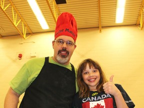 Satoo school Grade 5 student Trin Nelson and her dad Clarence Nelson serve up some Norwegian cuisine during the Mill Woods school's Taste of Satoo event last week. KEVIN MAIMANN/Edmonton Examiner