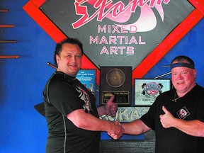 Eye of the Storm Mixed Martial Arts owner Derrick Soroka (left) congratulates Park powerlifter Colin Bonneau on his latest collection of world titles. Photo by Shane Jones/Sherwood Park News/QMI Agency