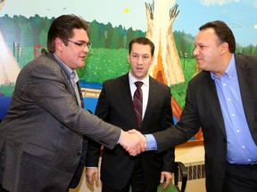 Saugeen First Nation Chief Randall Kahgee, right, and Chippewas of Nawash Chief Scott Lee, left, shake hands after they ceremonially signed a new five-year commercial fishing agreement with Natural Resources Minister David Orazietti, centre, at the Saugeen Reserve Band Office on Monday. James Masters/The Sun Times.