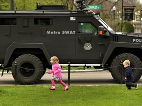 Kids run past a SWAT truck in Boston Commons on April 20, 2013 as people get back to the normal life the morning after after the capture of  the second of two suspects wanted in the Boston Marathon bombings. Thousands of heavily armed police staged an intense manhunt Friday for a Chechen teenager suspected in the Boston marathon bombings with his brother, who was killed in a shootout. Dzhokhar Tsarnaev, 19, defied the massive force after his 26-year-old brother Tamerlan was shot and suffered critical injuries from explosives believed to have been strapped to his body.  (AFP PHOTO / TIMOTHY A. CLARY)