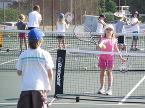 Pictured is Nicole Pineau at the main clubhouse courts on Lake Street, showing what happens during the lessons for the youngest participants. They use racquets and nets appropriate for their sizes and also balls that bounce the correct height for them to progress and have success. The youngest classes for this coming summer will be held from 8:30 a.m. to 9:15 a.m. and 9:15 a.m. to 10 a.m. every weekday morning.