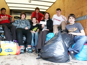 Grade 8 students Tyler Foxe-MacKenzie, left, Brayden Ferrell, Cole Amy, Sam McLeod, back, principal Sharon Lytle, Justin Faux and Dylan Clark of Paris Central School pose with 1,000 kilograms of used clothing, shoes, purses, stuffed animals, etc. donated from the community to the school's Bag 2 School fundraiser. The exactly one metric-tonne collection of items fetched the school a cheque for $200. MICHAEL PEELING/The Paris Star/QMI Agency