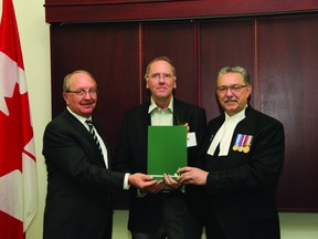 Airdrie, Alta. — Camile Huisma, centre, founder and co-CEO of GrowSafe Systems, stands with MLA for Drumheller-Stettler Rick Strankman, left, and Hon. Gene Zwozdesky, Speaker of the Legislative Assembly of Alberta, right. Huisma was presented with a Nomination Certificate for the Ernest C. Manning Awards at the Legislature on April 16.