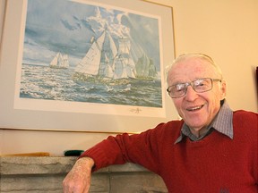 Francis MacLachlan helped design and build the brigantine St. Lawrence II, which is now celebrating its 60th anniversary. He is standing in front of a painting showing the St. Lawrence II, at left, with her sister ships the Pathfinder and the Playfair. (Michael Lea The Whig-Standard)
