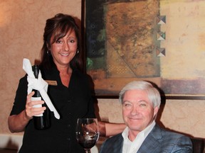 Days Inn dining room hostess Lise Anne Cormier and Days Inn owner J.P.  Aubé were collaborating this week on the special wine that will be served at the 15th annual Days Inn Spring Ball in support of the Timmins and District Hospital Foundation. Timmins Times Local News photo by Len Gillis.