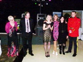 Pat and Greg Littleton (left) purchased a framed print at the Emergency Services Ball and donated it to be auctioned off to benefit Project Brock - represented here by Kim Ruether, Liz Campbell, Lil Riegling and Corporal Brad Giles of the Fairview RCMP. The auction raised $2000 and Chip Moffatt donated another $400 to make up the purchase price of an AED.