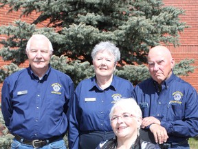 KEVIN RUSHWORTH PHOTO. At front, Linda Nelson smiles in her donated wheelchair. In the back row from left to right are Tom Carson, Highwood Lions Club past president, club treasurer Christina Carson and Lions club member Jeff Jackson.