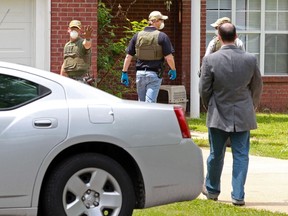 A FBI agent stops homeowner James E. Dutschke from approaching his home in Tupelo, Mississippi April 23, 2013 while the agents begin to search his home for any clues into the ricin attack on Sen. Roger Wicker and President Barack Obama.  REUTERS/Thomas Wells/Daily Journal