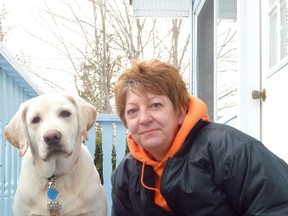 Cara Miller sits on the steps at her Heyden home with Buddy, the family dog