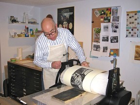 Ralph Heather in his Paris studio pulling an original woodcut print.
