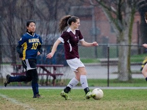 Frontenac Falcons’ Miriam Franchetto drives the ball past Napanee Golden Hawks Courtney Sutherland and Sarah Fabius during a Kingston Area Secondary Schools Athletic Association senior girls soccer game played in the rain at Frontenac on Wednesday. Franchetto scored four goals to lead the Falcons to a 6-1 victory. (Julia McKay/For The Whig-Standard)