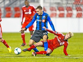 Toronto FC’s Kyle Bekker slides the ball away from Montreal Impact FC’s Andrew Wenger Wednesday night at BMO Field. (ERNEST DOROSZUK/Toronto Sun)