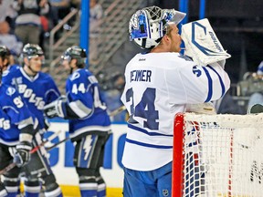 Leafs goalie James Reimer takes a drink after giving up a goal Wednesday night to the Tampa Bay Lightning, seen celebrating in the background. (REUTERS)