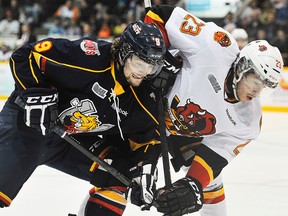 Belleville Bulls rookie forward Niki Petti battles with Barrie Colts forward, and former Bull, Dylan Corson, during OHL playoff action Wednesday night at the Molson Centre in Barrie. (Mark Wanzel/QMI Agency)
