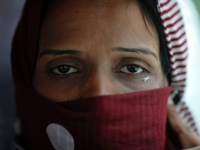 An Ahmadi Muslim from Pakistan weeps as she leaves a detention centre in Bangkok, where her family fled using tourist visas to escape religious repression at home.