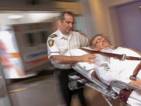 Randy Papple of the Brant County Ambulance Service wheels a patient into the emergency department at Brantford General Hospital. City council has agreed to bridge funding to help pay for an "offloading" nurse at BGH. (BRIAN THOMPSON,  The Expositor)