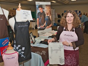 Lee Overton, co-owner of domistyle, shows her aprons and kitchen textiles at the Enterprise Brant trade show on Thursday at the Best Western Brant Park Inn. (BRIAN THOMPSON, The Expositor)