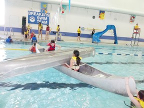 Pictured are the Scouts practicing what to do when a canoe has flipped over. They are working as a team to empty the flipped canoe of water by using the other canoe, then getting back into the restored canoe safely.