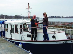 Chuckles Discovery Tours’ Captain Lance and Thousand Islands Playhouse marketing manager Debbie Bennett celebrate the arrival of Chuckles the boat to their dock in Gananoque. The Playhouse will launch a new cruise and theatre initiative this season with a ceremony on May 1.    SUBMITTED PHOTO